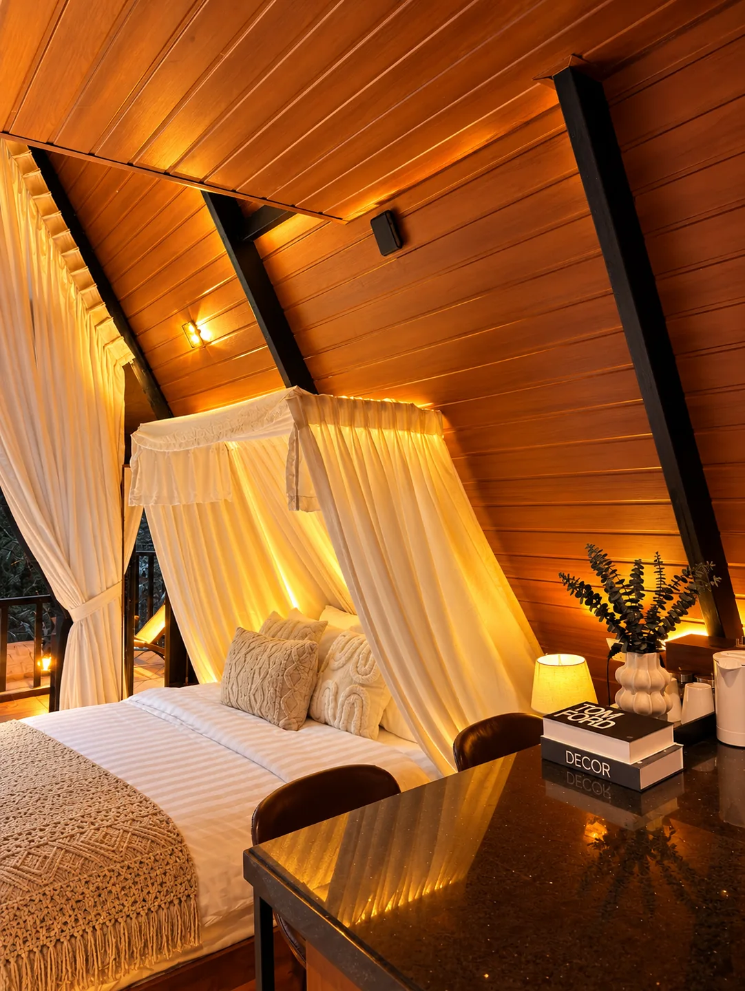A canopy bed inside the warm timber A-frame bedroom